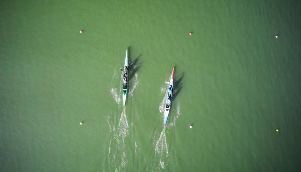 two boats sculling across rowing canal - rowboat sport rowing team sports race imagens e fotografias de stock