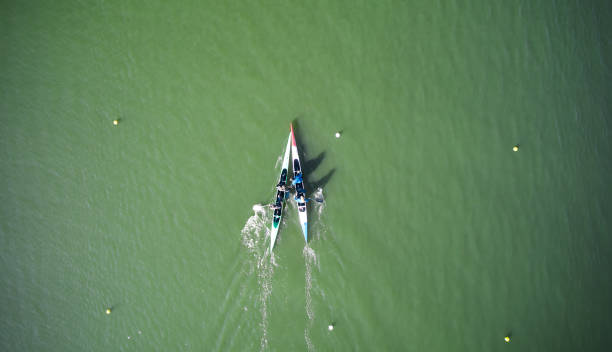 two boats sculling across rowing canal and meeting in the center - rowboat sport rowing team sports race imagens e fotografias de stock