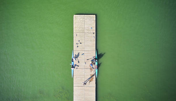the pier with two rowing boats on the water - rowboat sport rowing team sports race imagens e fotografias de stock