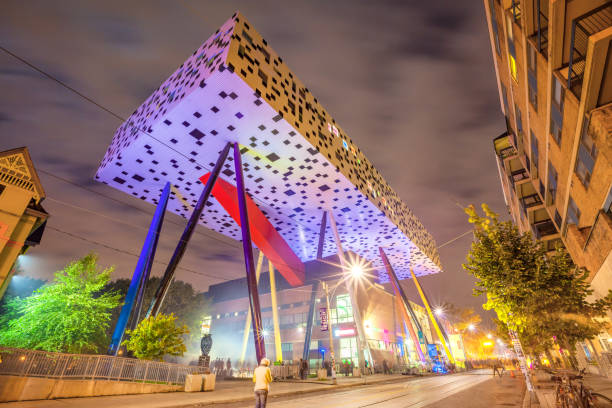 Pedestrian walks below the landmark OCAD University building in downtown Toronto Ontario Canada at night.