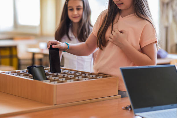 School children placing phones in a box before class