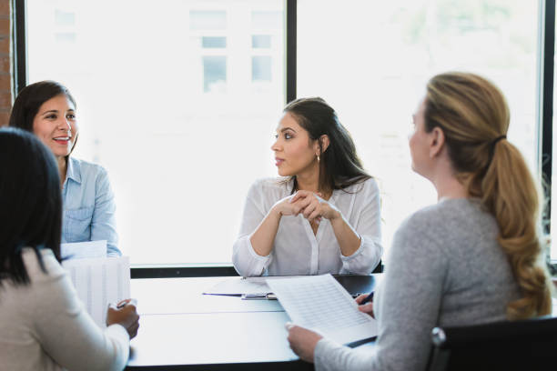 istock Group of co-workers meet in conference room to discuss spreadsheet 1329102183