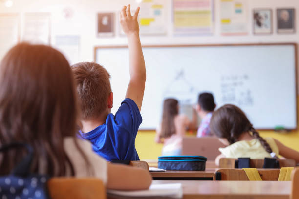 enfant levant la main en classe - blackboard child thinking little girls photos et images de collection