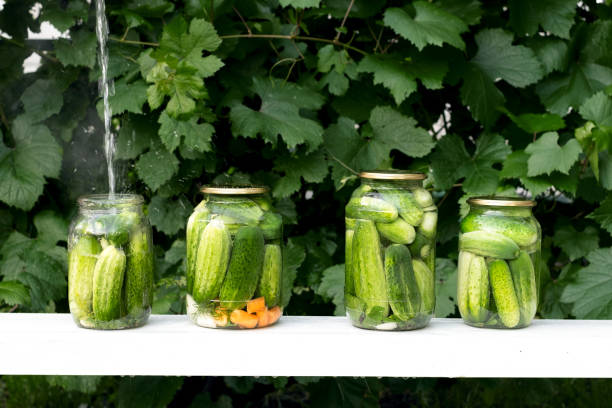 istock Four cans of fresh cucumbers are filled with boiled marinade 1329106444