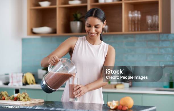 Cropped Shot Of An Attractive Young Woman Making Smoothies In Her Kitchen At Home Stock Photo - Download Image Now