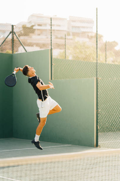 istock Paddle tennis player servicing ball in the air 1329108872
