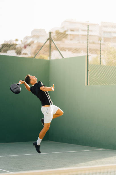 istock Paddle tennis player servicing ball in the air 1329108920