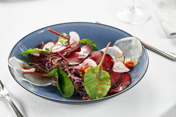 istock Light appetizer bresaola with lettuce, Italian bresaola beef jerky on a light plate, close-up, copy space 1329114884