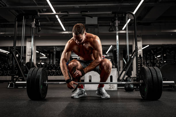 istock Athlete, bodybuilder exercise with a barbell, athlete prepares the barbell for exercise, beautiful body, healthy lifestyle 1329114970