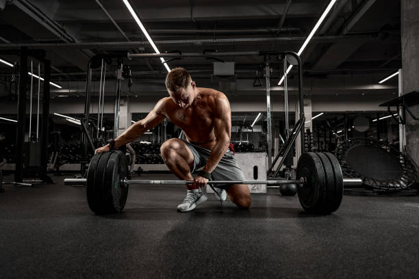istock Athlete, bodybuilder exercise with a barbell, athlete prepares the barbell for exercise, beautiful body, healthy lifestyle 1329114975