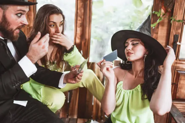 Photo of Male Fortune Teller Shocked By Tarot Card Pick By Beautiful Female Witch