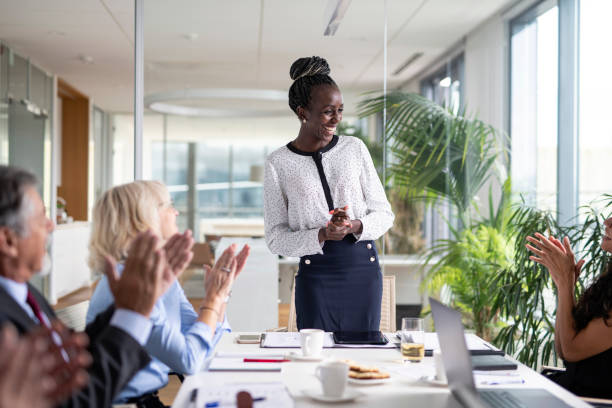 un groupe diversifié de cadres applaudit les femmes africaines pdg - board room business person meeting business photos et images de collection