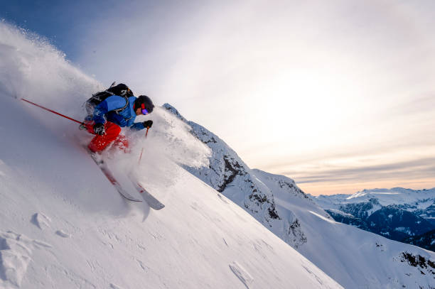 un skieur de l’arrière-pays descend une crête de montagne enneigée - telemark skiing photos photos et images de collection