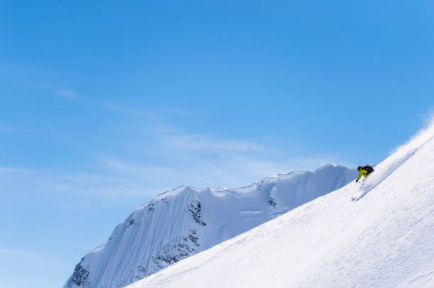 istock Backcountry skier descends snowy mountain ridge 1329128219
