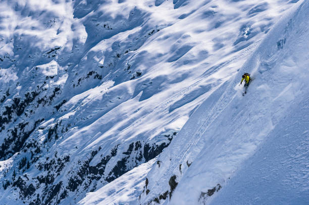istock Backcountry skier descends snowy mountain ridge 1329128228