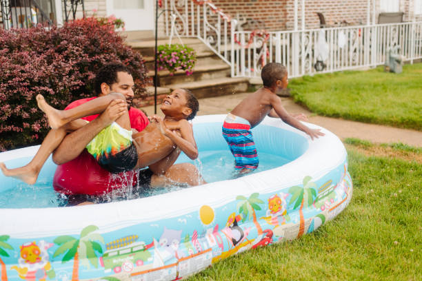 istock Kids playing in kiddy pool with their dad. 1329131947