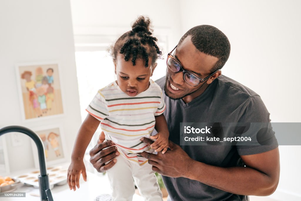 Dad on duty today Dad and toddler in the kitchen 12-17 Months Stock Photo