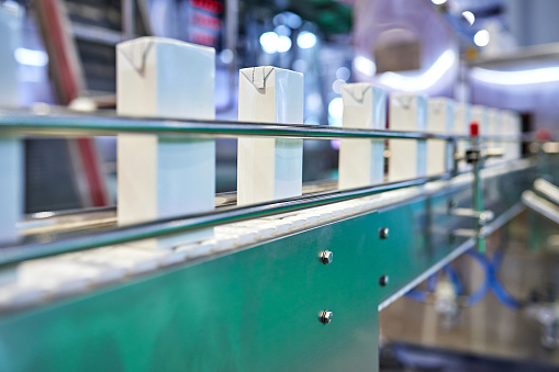 Close-up of blank juice box at production line.