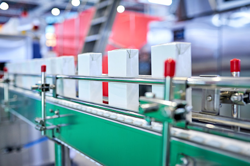 Close-up of blank juice box at production line.