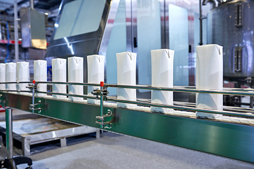 Side view of blank milk carton at production line.
