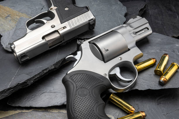 istock Revolver and automatic handgun on black stone background 1329138643