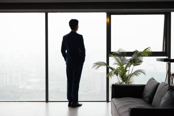 istock Asian business man standing by the window 1329140393