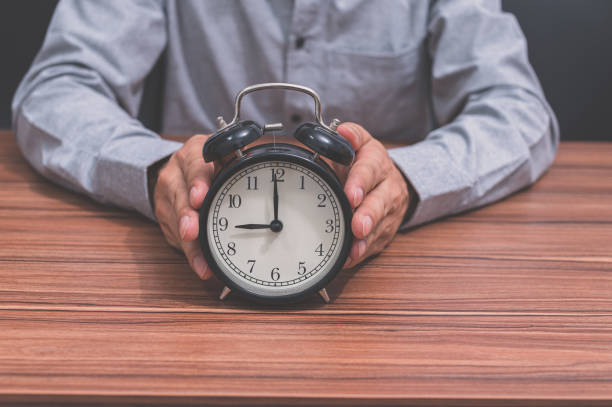 istock A human hand holds a clock showing the time 1329144998