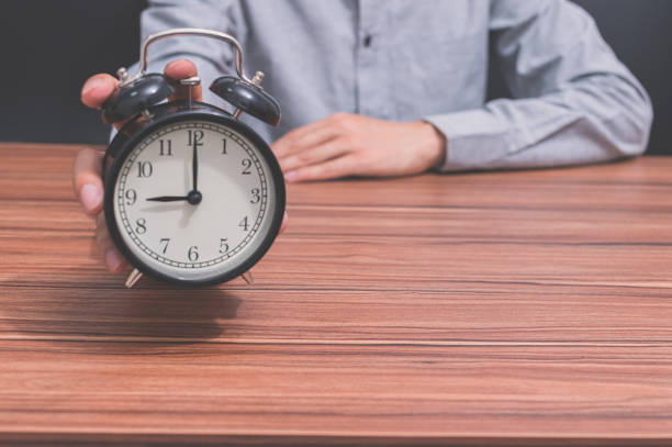 istock A human hand holds a clock showing the time 1329145001