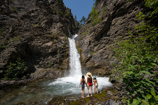 Family on a summer vacation. Mother and daughters on an adventure. Chasing waterfalls on summer vacation.