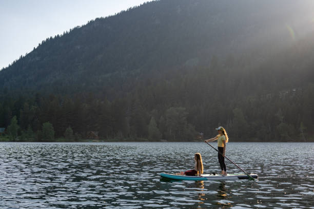 istock Mother and daughter on a paddle board adventure 1329146096
