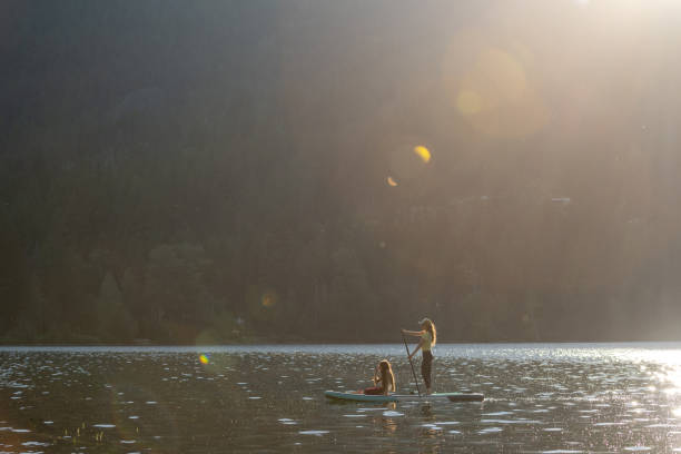 istock Mother and daughter on a paddle board adventure 1329146098