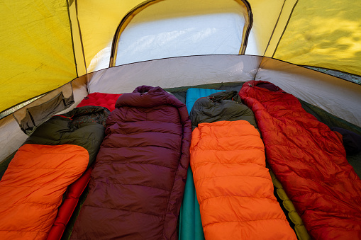 Family camping setup. Sleeping bags and air mattresses in a tent. Camping equipment.