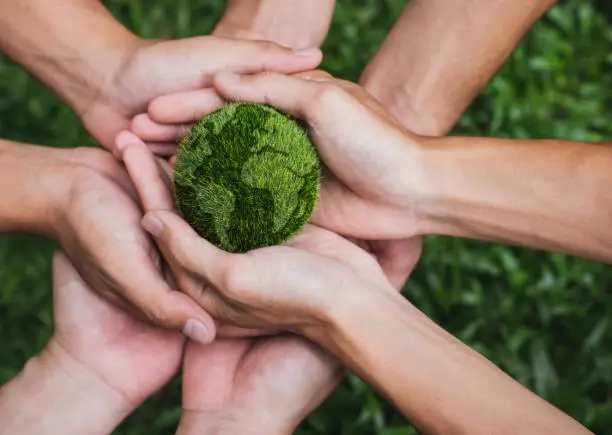 Photo of Earth Day. Hands adult Teamwork harmony Holding earth on hands. Environmental and reduce global warming help earth, top view. ecology and environment sustainable concept.