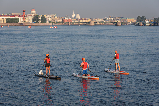 Saint Petersburg, Russia - July 10, 2021: paddleboarders sail in the Neva River in the historical part of the city.