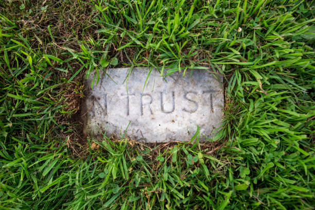 istock Ancient grave marker reads In Trust surrounded by green grass 1329154634