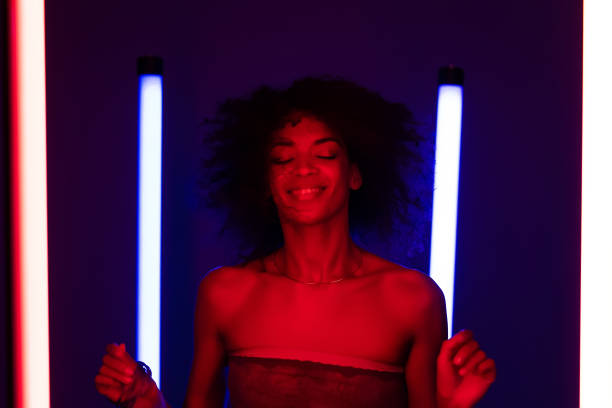 istock Cool disco dancing unique afro woman under neon glowing light. Multi colored shot of lady moving to music rhythm. Millennial hipster generation. Party concept. 1329157117