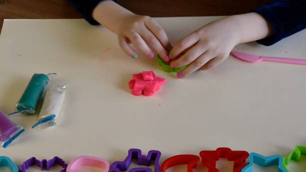 istock Toddler hands playing colorful play dough with plastic molds 1329161291