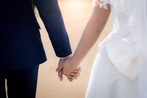 istock Bride and Groom Holding Hands outdoors in wedding event 1329163347