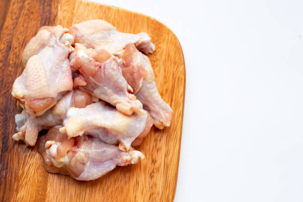 istock Fresh raw chicken wings (wingstick) on cutting board on white background. 1329168082