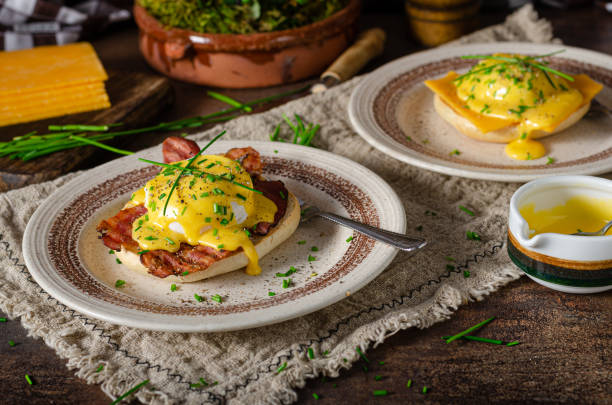 Delicious eggs benedict Organcic eggs benedict with bacon, cheddar cheese and herbs and hollandaise sauce hollandaise sauce stock pictures, royalty-free photos & images