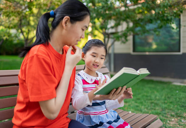 istock Little Girl and Mother Reading Book 1329169012