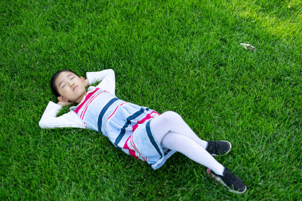 istock Cute girl Lying Down on the Grass 1329172293