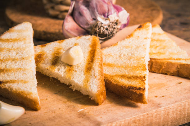 Triangular crispy toasts with garlic for soups and vegetable dishes on a board close-up