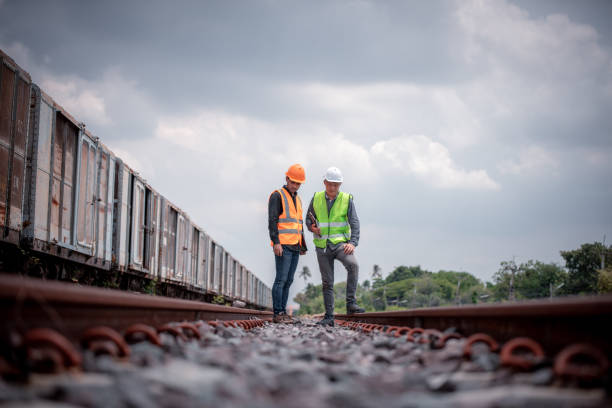 ingeniero bajo inspección de la discusión y comprobación del interruptor ferroviario del proceso de construcción y comprobación del trabajo en la estación de ferrocarril. ingeniero con uniforme de seguridad y casco de seguridad en el trabajo. - transporte ferroviario fotografías e imágenes de stock