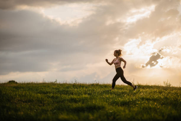 istock Woman jogging on the meadow 1329173412