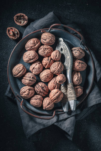 istock Brown walnuts on rustic metal plate. Quick and good snack. 1329180130