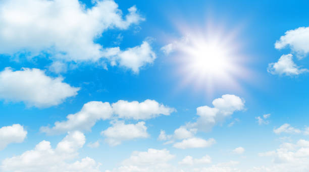 istock Sunny day background, blue sky with white cumulus clouds and glaring sun 1329181707
