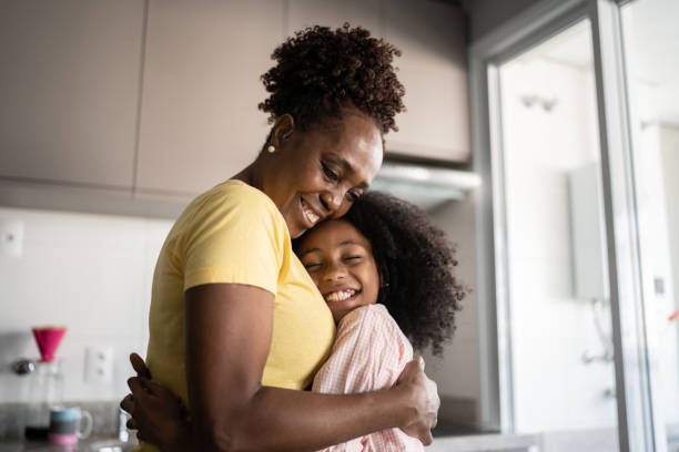 istock Mother and daughter embracing at home 1329181801