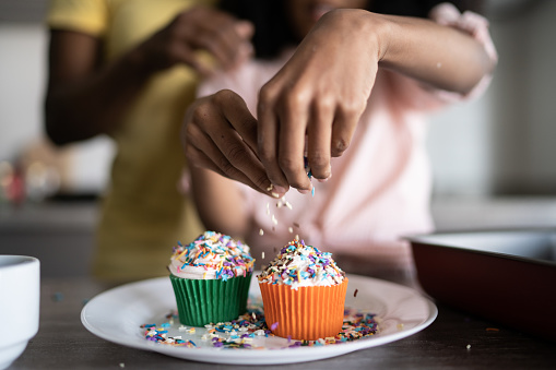 Girl decorating some cupcakes at home