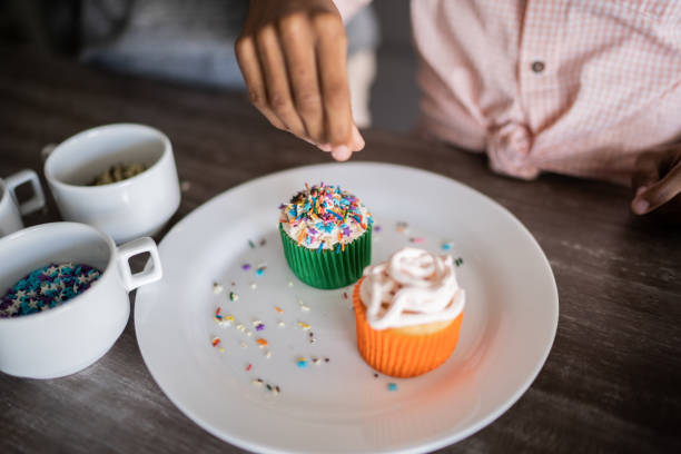 istock Girl decorating some cupcakes at home 1329182179